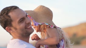 El padre coge a la niña en sombrero en el mar en lento almacen de video El padre coge a la niña en sombrero en el mar en lento almacen de video