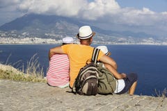 El padre, la hija y el hijo jovenes con las mochilas se están sentando en la playa contra el contexto del mar Concepto del viaje fotos de archivo libres de regalías El padre, la hija y el hijo jovenes con las mochilas se están sentando en la playa contra el contexto del mar Concepto del viaje fotos de archivo libres de regalías