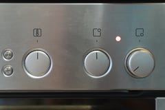 El panel de control de plata delantero de la estufa con cambiar de las manijas fotografía de archivo libre de regalías El panel de control de plata delantero de la estufa con cambiar de las manijas fotografía de archivo libre de regalías