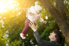 El papá lanza para arriba a la muchacha en parque del otoño Fotografía de archivo libre de regalías El papá lanza para arriba a la muchacha en parque del otoño Fotografía de archivo libre de regalías