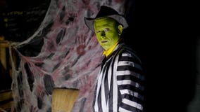 El partido de Halloween, noche, crepúsculo, en los rayos de la luz, un hombre con un maquillaje terrible, con una cara verde y un almacen de metraje de vídeo El partido de Halloween, noche, crepúsculo, en los rayos de la luz, un hombre con un maquillaje terrible, con una cara verde y un almacen de metraje de vídeo