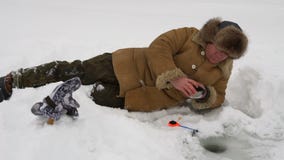El pescador coge un pescado en la pesca del hielo almacen de metraje de vídeo El pescador coge un pescado en la pesca del hielo almacen de metraje de vídeo