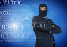 El pirata informático con la capilla y arma la situación cruzada encendido delante del fondo azul fotografía de archivo libre de regalías El pirata informático con la capilla y arma la situación cruzada encendido delante del fondo azul fotografía de archivo libre de regalías