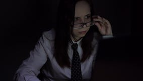 El recepcionista de la muchacha en el trabajo Empresaria joven atractiva que trabaja en la noche vía el ordenador en la oficina c El recepcionista de la muchacha en el trabajo Empresaria joven atractiva que trabaja en la noche vía el ordenador en la oficina c