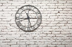 El reloj viejo del metal en blanco pintó la pared de ladrillo del grunge Imagen de archivo El reloj viejo del metal en blanco pintó la pared de ladrillo del grunge Imagen de archivo