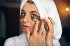 El retrato cosechado de la mujer hermosa con maquillaje natural pone remiendos en el área debajo de los ojos de arrugas y de círc fotos de archivo El retrato cosechado de la mujer hermosa con maquillaje natural pone remiendos en el área debajo de los ojos de arrugas y de círc fotos de archivo