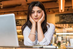 El retrato de la empresaria joven, estudiante, se vistió en la blusa blanca, sentándose en la tabla en café delante del ordenador fotografía de archivo libre de regalías El retrato de la empresaria joven, estudiante, se vistió en la blusa blanca, sentándose en la tabla en café delante del ordenador fotografía de archivo libre de regalías