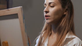 El retrato de la muchacha de The del artista se coloca en el caballete, pinta una imagen, ella está muy interesado 4K MES lento metrajes El retrato de la muchacha de The del artista se coloca en el caballete, pinta una imagen, ella está muy interesado 4K MES lento metrajes