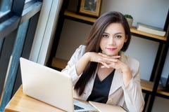 El retrato de la mujer de negocios asiática hermosa y confiada en edad de trabajar usando la tecnología del ordenador portátil de imagen de archivo libre de regalías El retrato de la mujer de negocios asiática hermosa y confiada en edad de trabajar usando la tecnología del ordenador portátil de imagen de archivo libre de regalías