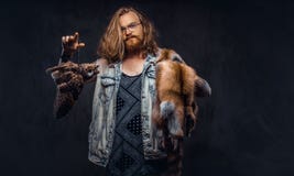 El retrato de un varón tattoed del inconformista del pelirrojo con el pelo lujuriante largo y la barba llena se vistió en una cam imágenes de archivo libres de regalías El retrato de un varón tattoed del inconformista del pelirrojo con el pelo lujuriante largo y la barba llena se vistió en una cam imágenes de archivo libres de regalías