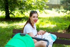 El retrato de una madre y de un bebé bonitos de oficio de enfermera, mamá joven está afuera con su niño recién nacido para el pas foto de archivo El retrato de una madre y de un bebé bonitos de oficio de enfermera, mamá joven está afuera con su niño recién nacido para el pas foto de archivo