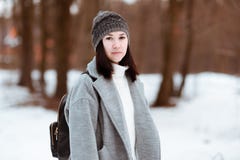 El retrato de una muchacha hermosa feliz con el pelo marrón en el bosque del invierno se vistió en un estilo del inconformista, f imagen de archivo El retrato de una muchacha hermosa feliz con el pelo marrón en el bosque del invierno se vistió en un estilo del inconformista, f imagen de archivo