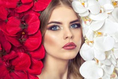 El retrato de una mujer con maquillaje hermoso sostiene una orquídea blanca y roja en sus manos foto de archivo libre de regalías El retrato de una mujer con maquillaje hermoso sostiene una orquídea blanca y roja en sus manos foto de archivo libre de regalías