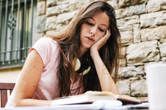 El sentarse femenino hermoso joven exterior y el estudiar difícilmente fotografía de archivo El sentarse femenino hermoso joven exterior y el estudiar difícilmente fotografía de archivo