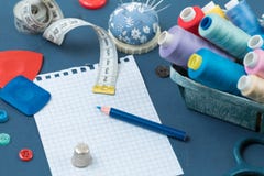 El sistema de bobinas multicoloras con los hilos para coser, es tiza para la tela, accesorios de costura y una hoja para los expe foto de archivo El sistema de bobinas multicoloras con los hilos para coser, es tiza para la tela, accesorios de costura y una hoja para los expe foto de archivo