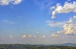 El Skydiver vuela al horizonte a través de las nubes foto de archivo El Skydiver vuela al horizonte a través de las nubes foto de archivo
