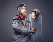 El snowboarder brutal del pelirrojo con una barba llena en un sombrero y vidrios protectores del invierno se vistió en una capa d foto de archivo libre de regalías El snowboarder brutal del pelirrojo con una barba llena en un sombrero y vidrios protectores del invierno se vistió en una capa d foto de archivo libre de regalías