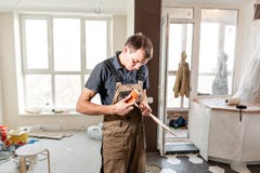 El trabajador de sexo masculino corta al tablero laminado instalación del nuevo suelo laminado de madera concepto de reparación e fotografía de archivo El trabajador de sexo masculino corta al tablero laminado instalación del nuevo suelo laminado de madera concepto de reparación e fotografía de archivo