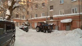 El tractor limpia la yarda de nieve El tractor limpia la yarda de nieve