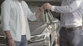 El vendedor sacude las manos con el comprador después de comprar el coche almacen de video El vendedor sacude las manos con el comprador después de comprar el coche almacen de video