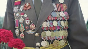 El veterano de la grandes guerra y Segunda Guerra Mundial patrióticas en uniforme con muchas insignias y órdenes viene con las fl El veterano de la grandes guerra y Segunda Guerra Mundial patrióticas en uniforme con muchas insignias y órdenes viene con las fl