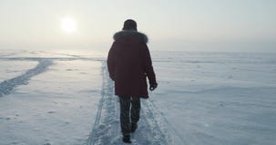 El viajero joven pasa a través de una ventisca en la puesta del sol hermosa Expedición polar El viajero joven pasa a través de una ventisca en la puesta del sol hermosa Expedición polar