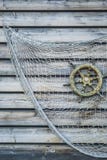 El volante de madera de la nave nostálgica con la red de pesca ató t Fotos de archivo libres de regalías El volante de madera de la nave nostálgica con la red de pesca ató t Fotos de archivo libres de regalías