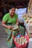Elderly burmese woman showing how to make fresh Thanaka cosmetic paste