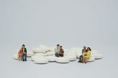 Elderly couple family figure sitting on a pile of white pills royalty free stock images Elderly couple family figure sitting on a pile of white pills royalty free stock images