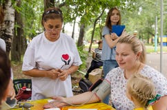Elderly female volunteer getting ready to measure blood pressure in an attractive fat young woman. care about the health of women stock images Elderly female volunteer getting ready to measure blood pressure in an attractive fat young woman. care about the health of women stock images