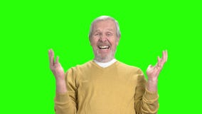 Elderly man laughing on green screen.