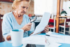Elderly woman looking at her utility bills Royalty Free Stock Image Elderly woman looking at her utility bills Royalty Free Stock Image