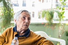 Elderly woman sitting in the balcony having conversation with her family. Stock Photography Elderly woman sitting in the balcony having conversation with her family. Stock Photography