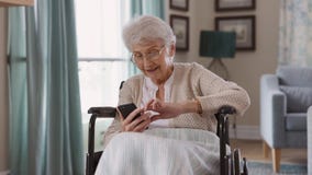 Senior woman using smartphone on wheelchair