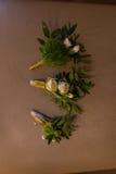 Elegancki boutonniere fornal i jego przyjaciele Trzy boutonnieres w beżowych kolorach kłamają na brown tle zdjęcie royalty free Elegancki boutonniere fornal i jego przyjaciele Trzy boutonnieres w beżowych kolorach kłamają na brown tle zdjęcie royalty free