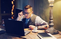 Elegancki dorosły mężczyzna pracuje w domu podczas gdy siedzący przy drewnianym stołem Używać nowożytnego laptop dla badawczych n Fotografia Stock Elegancki dorosły mężczyzna pracuje w domu podczas gdy siedzący przy drewnianym stołem Używać nowożytnego laptop dla badawczych n Fotografia Stock
