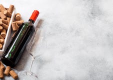 Elegant glass and bottle of red wine with corks on stone kitchen table background. Top view. Space for text royalty free stock photography Elegant glass and bottle of red wine with corks on stone kitchen table background. Top view. Space for text royalty free stock photography
