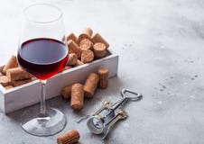 Elegant glass of red wine with box of corks and opener on stone kitchen table background stock images Elegant glass of red wine with box of corks and opener on stone kitchen table background stock images