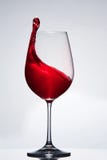 Elegant pure wineglass with wave of brightly red wine standing against light background with reflection in down. royalty free stock photos Elegant pure wineglass with wave of brightly red wine standing against light background with reflection in down. royalty free stock photos