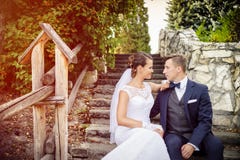 Elegant stylish young bride and groom sitting on the stairs in the park Stock Photo Elegant stylish young bride and groom sitting on the stairs in the park Stock Photo