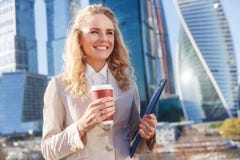 Elegante Geschäftsfrau in der beige Jacke während des Bruches mit Kaffee stockbilder Elegante Geschäftsfrau in der beige Jacke während des Bruches mit Kaffee stockbilder