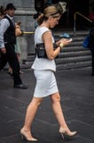Elegante junge Frau, die ihr Telefon geht und überprüft stockfoto Elegante junge Frau, die ihr Telefon geht und überprüft stockfoto