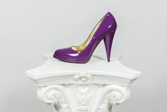 Elegante purpere vrouwelijke high-heeled leerschoen op Griekse kolom stock afbeeldingen Elegante purpere vrouwelijke high-heeled leerschoen op Griekse kolom stock afbeeldingen