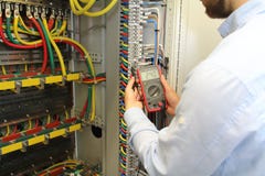 Elektriker arbeitet im Verteilungs-Sicherungskasten der elektrischen Kabel mit Vielfachmessgerät stockbilder Elektriker arbeitet im Verteilungs-Sicherungskasten der elektrischen Kabel mit Vielfachmessgerät stockbilder