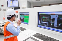 Elektroingenieur, der an der Leitstelle der thermischen Macht arbeitet Stockfotografie Elektroingenieur, der an der Leitstelle der thermischen Macht arbeitet Stockfotografie