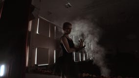 Elementos de baile de un ballet de la bailarina agraciada en la oscuridad con la luz y el humo en el fondo, cámara lenta almacen de metraje de vídeo Elementos de baile de un ballet de la bailarina agraciada en la oscuridad con la luz y el humo en el fondo, cámara lenta almacen de metraje de vídeo