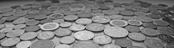 An elongated image with coins from different currencies in black and white stock photography An elongated image with coins from different currencies in black and white stock photography