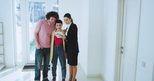 Em uma mulher moderna luminosa do mediador imobiliário da casa que mostra na casa a seus pares novos atrativos do cliente os vídeos de arquivo Em uma mulher moderna luminosa do mediador imobiliário da casa que mostra na casa a seus pares novos atrativos do cliente os vídeos de arquivo
