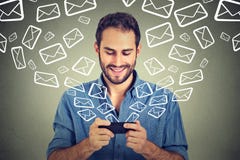 Emails för meddelanden för ung lycklig man för stående upptagna överförande från den smarta telefonen royaltyfri foto Emails för meddelanden för ung lycklig man för stående upptagna överförande från den smarta telefonen royaltyfri foto