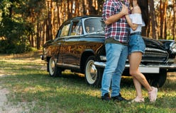 embrassez Amour et affection entre un jeune couple au parc, près de la vieille voiture un type dans un avion de plaid et des jean photos libres de droits embrassez Amour et affection entre un jeune couple au parc, près de la vieille voiture un type dans un avion de plaid et des jean photos libres de droits